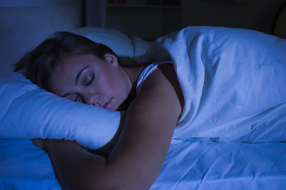 Young beautiful woman sleeping in bed in the dark