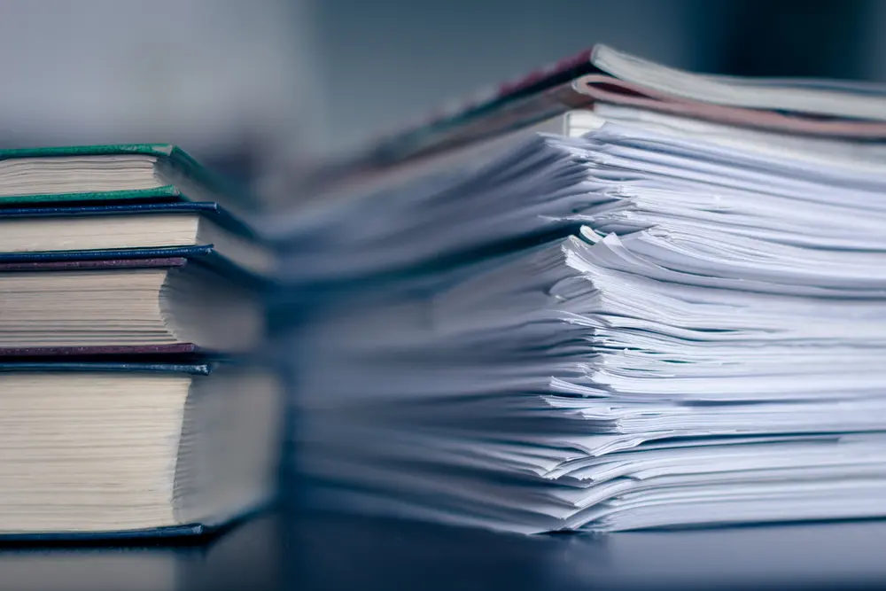 stack of papers next to a stack of books