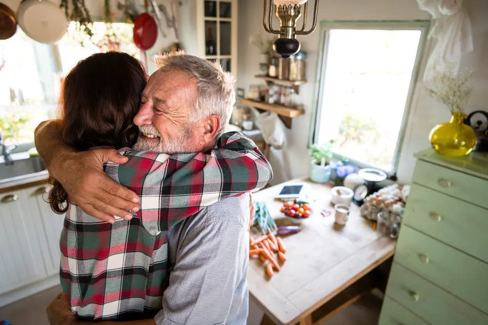man and daughter hugging when reuniting in a kitchen
